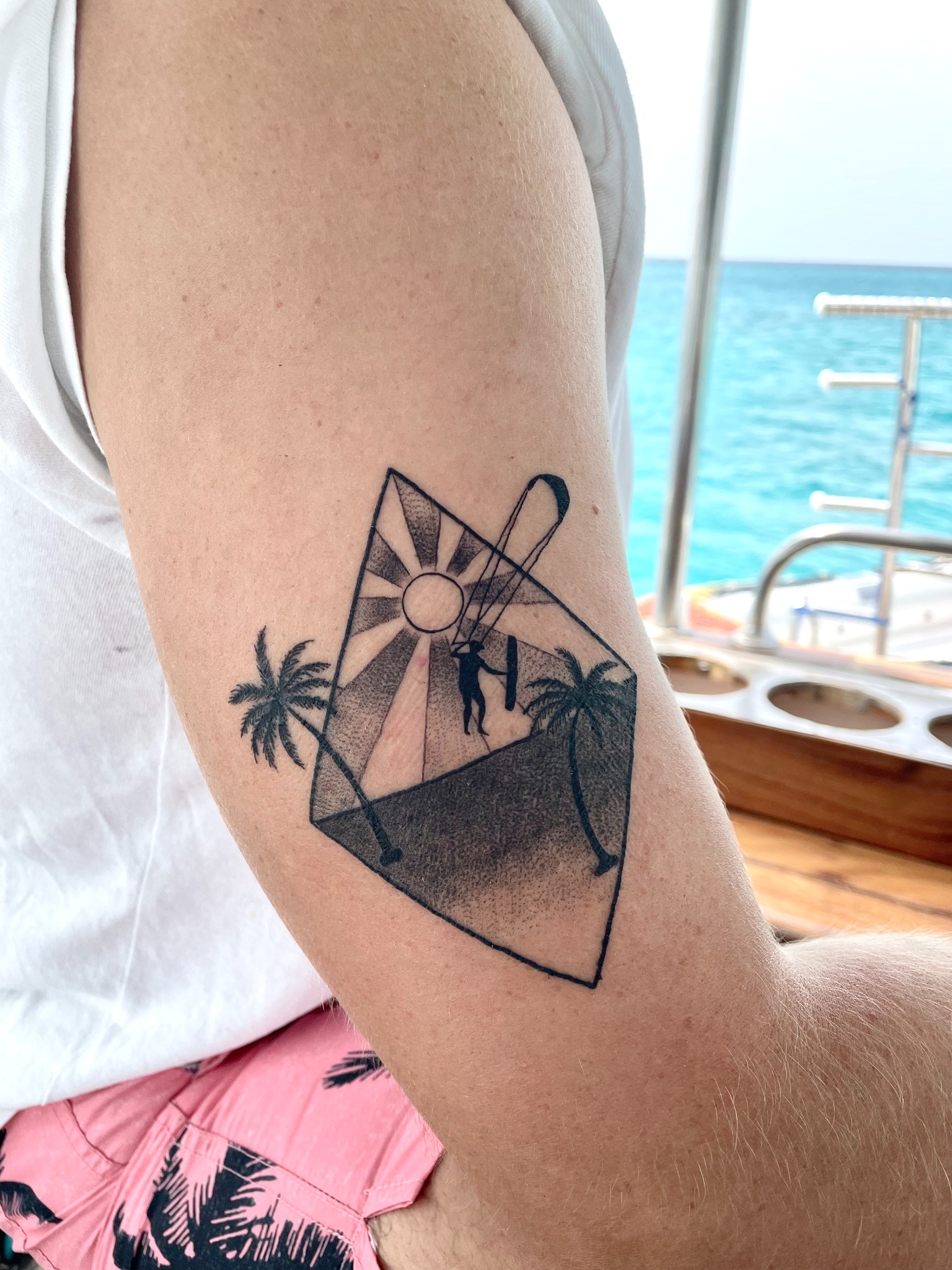 Personal kitesurfing tattoo with fine geometric lines, healed
