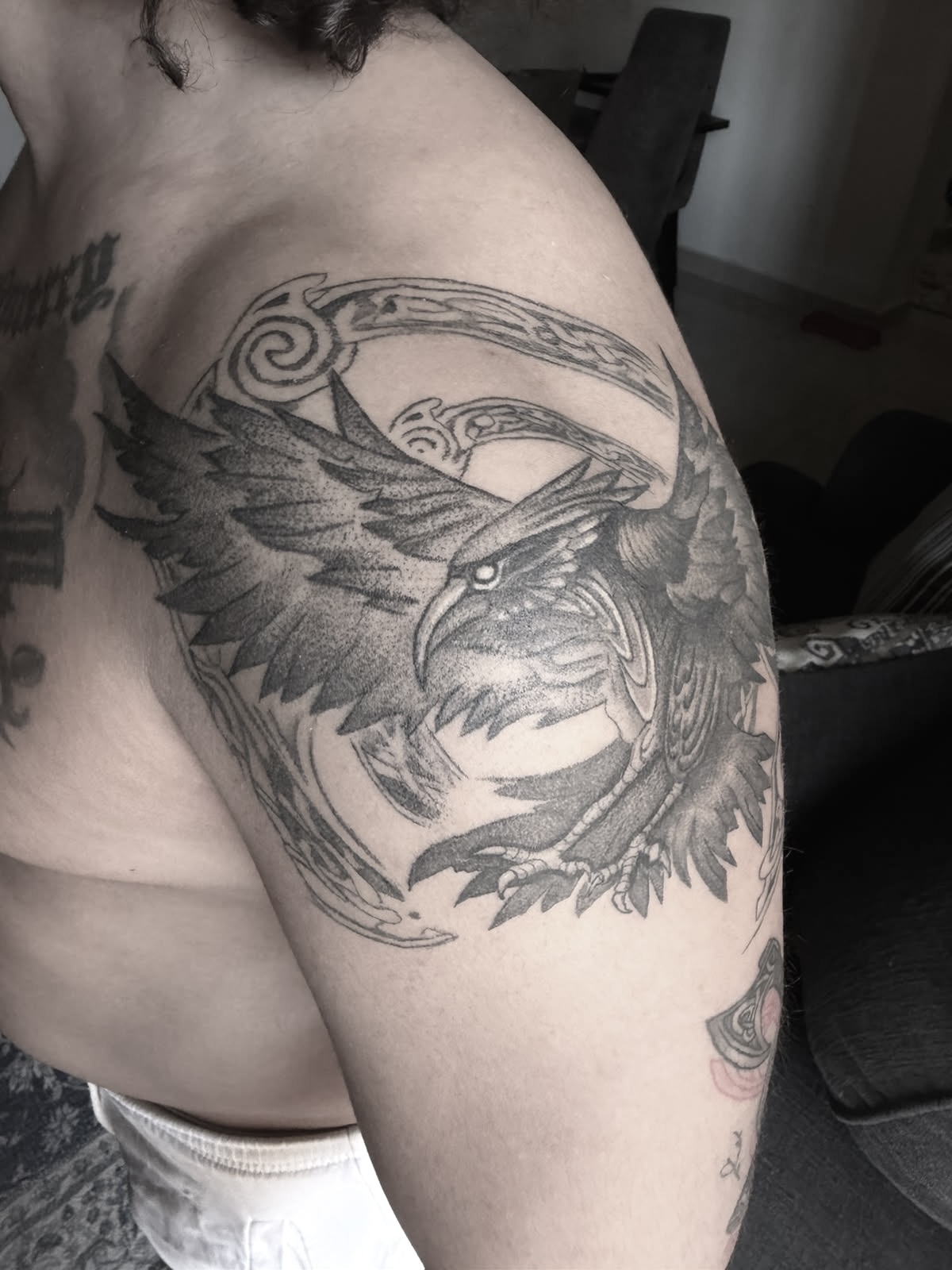 Healed raven tattoo on shoulder